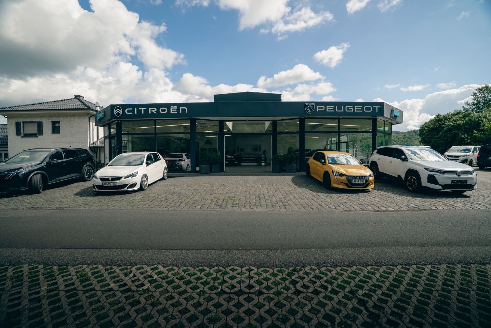 Das Autohaus Frensch von außen mit Citroën- und Peugeot-Schriftzug, davor mehrere Fahrzeuge